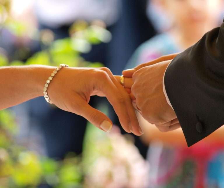 Un anneau de mariage est inséré dans le doigt